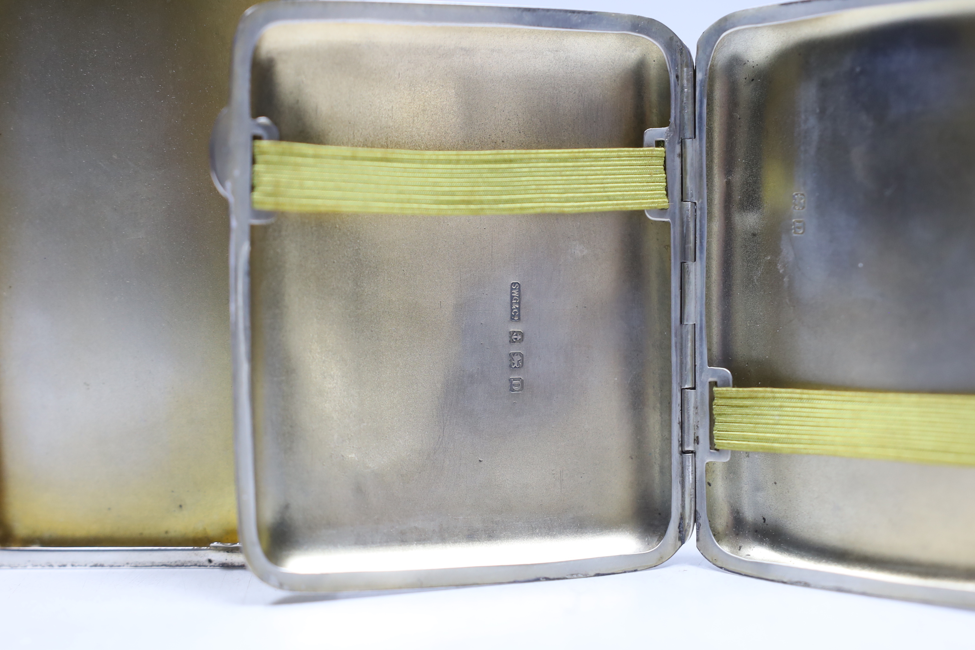 A George V engine turned silver cigarette case, Birmingham, 1935, 10.2cm and one other earlier silver cigarette case.